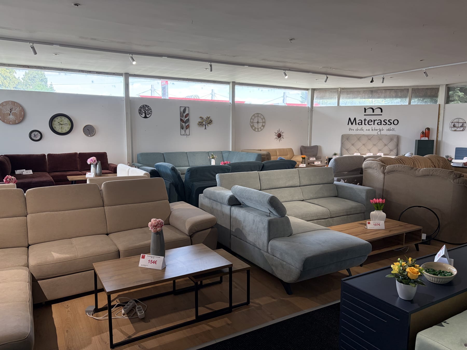 Viaceré sedacie súpravy a posteľ v interiéri showroomu Viaceré sedacie súpravy a posteľ v interiéri showroomu